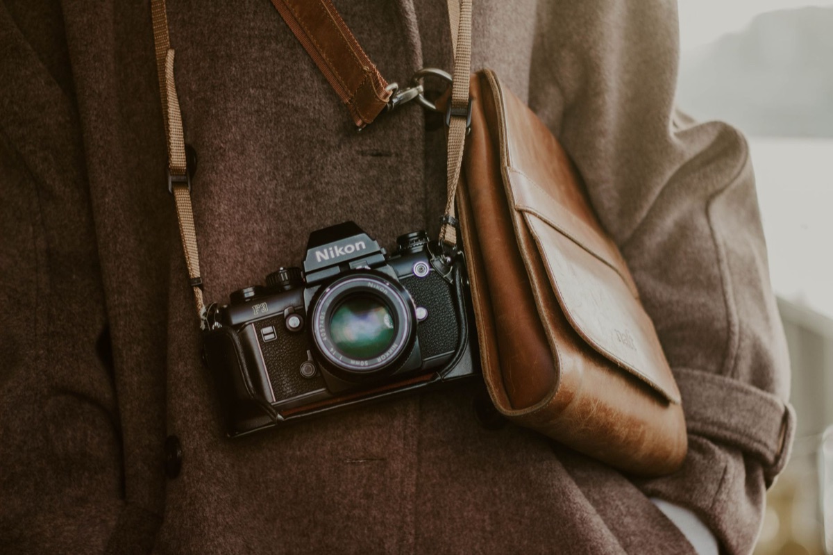 A worn leather strap adjacent to camera equipment