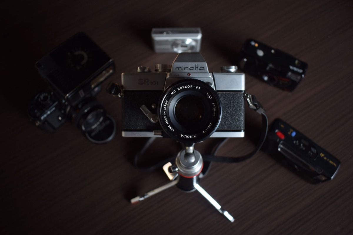 Minolta camera parts assembly in workshop, metal and plastic components, industrial lighting