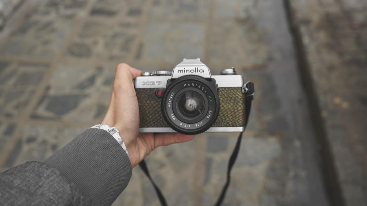 Historical photo of Minolta camera in 1950s, black and white, vintage setting, camera with focus mechanism