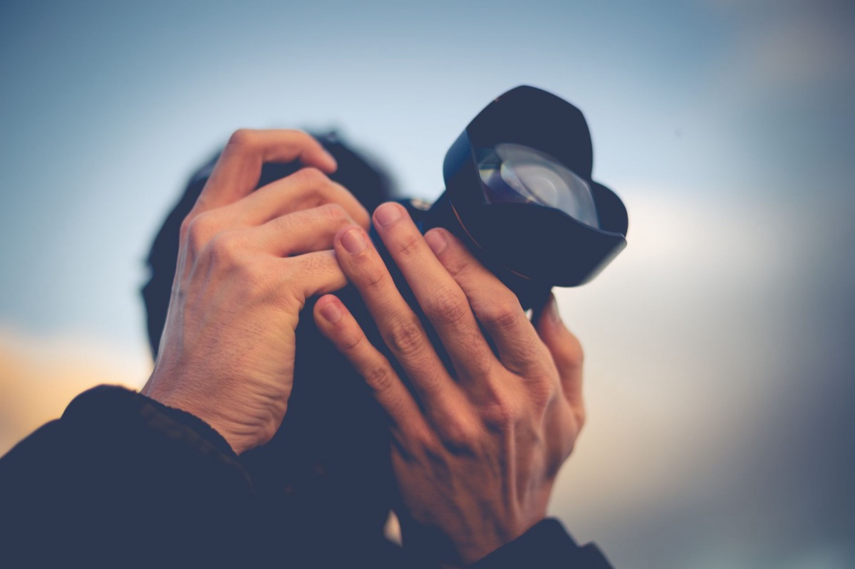 Fotografo che scatta una foto con una reflex professionale