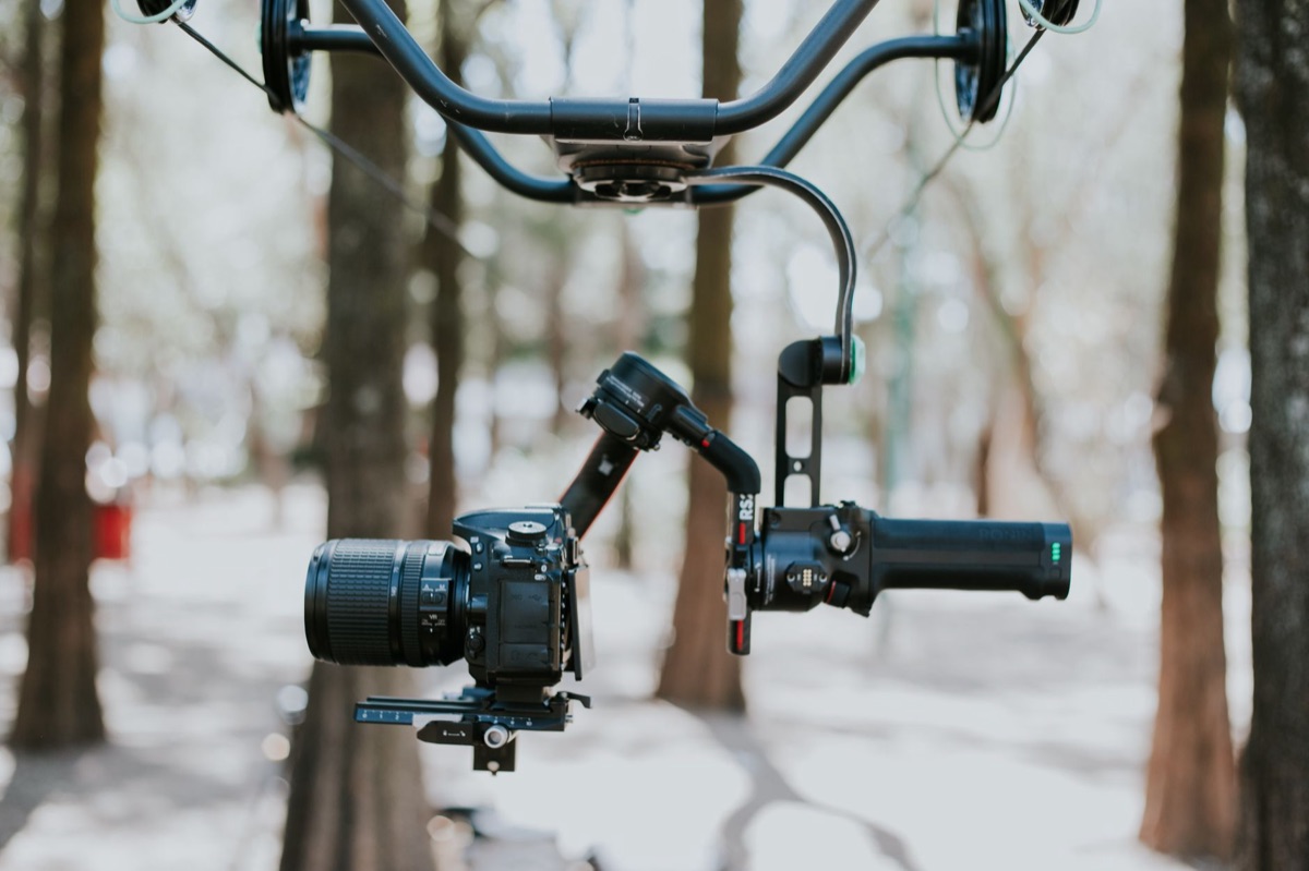 Close-up of a professional video camera lens reflecting studio lights.