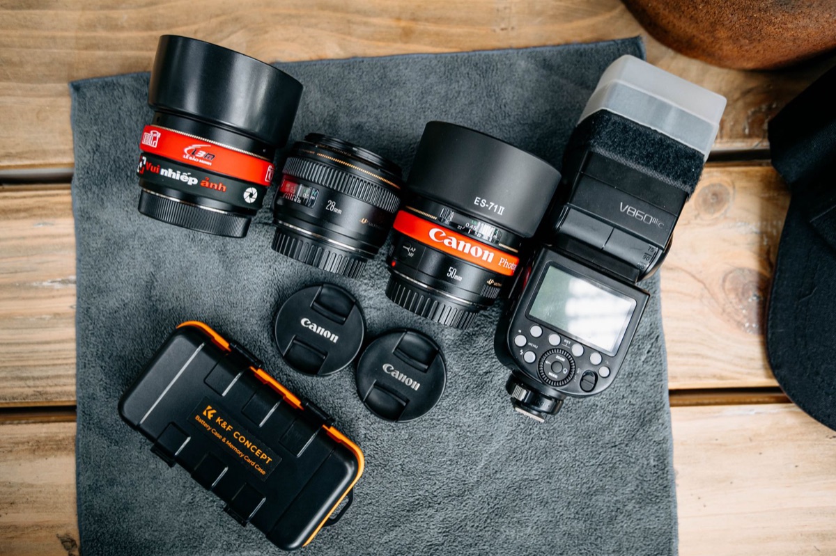 Kit de lentes de cámara y accesorios organizados en un bolso de viaje profesional.