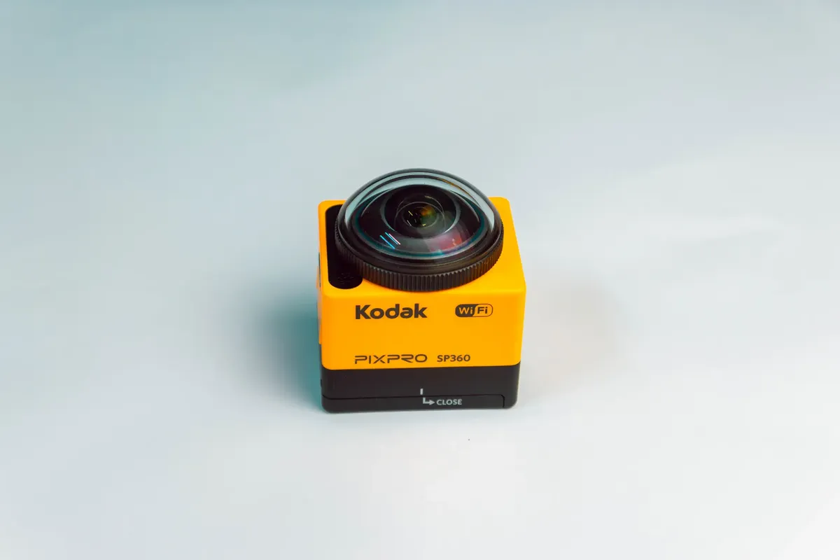 Compact yellow Kodak PIXPRO SP360 camera with fisheye lens against a gray background.