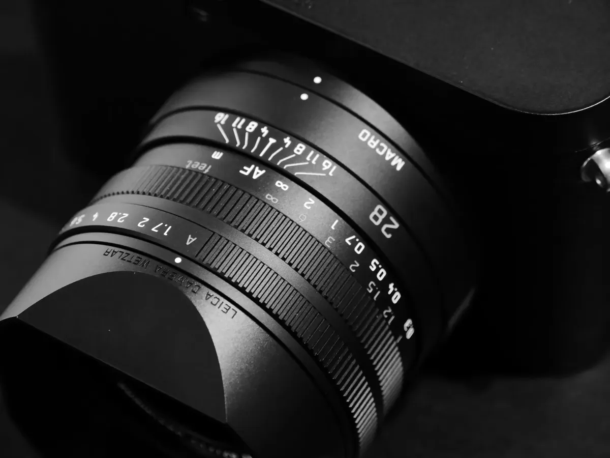 Detailed close-up of a professional camera lens, highlighting macro and aperture settings.