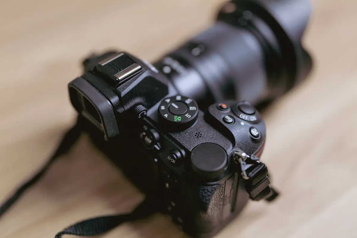 A detailed view of a DSLR camera on a wooden table showcasing its features.