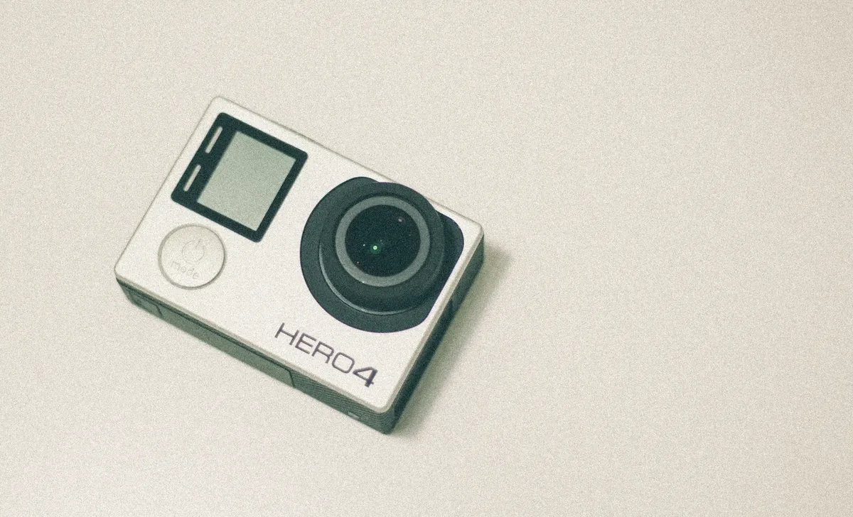 Top view of a GoPro Hero 4 action camera with a white background, emphasizing its design.